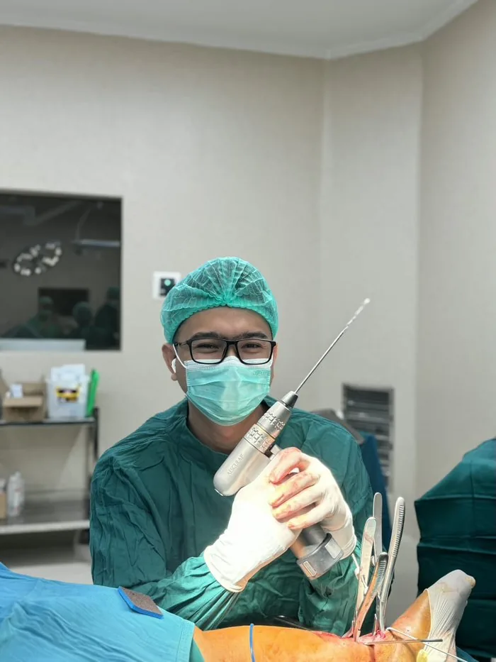 dr. Aries Fitrian SpB-ET, FICS performing surgery in the operating room